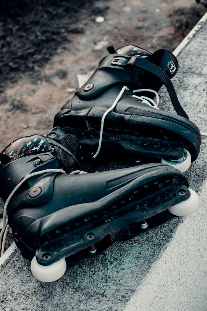 Black inline skates on urban ground, ideal for sports and adventure themes.