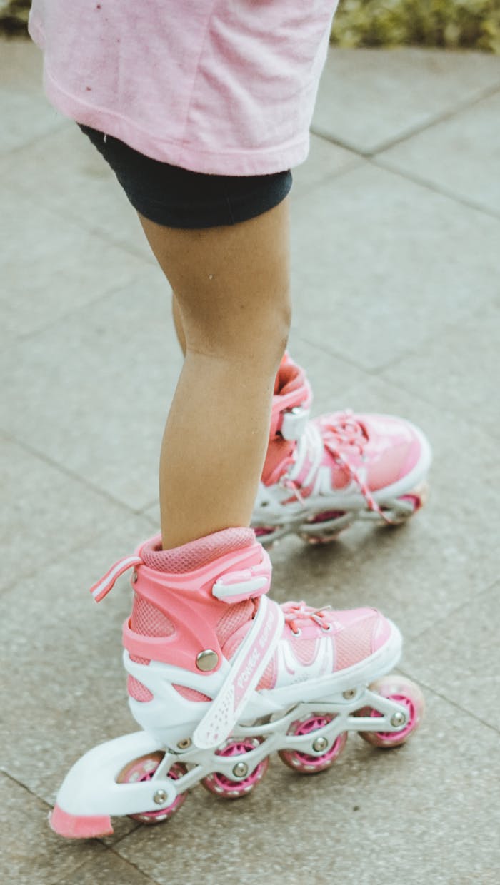 Close-up of a child roller skating in pink skates outdoors in West Java, Indonesia.